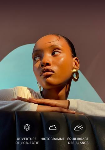 Portrait en gros plan d’une personne bien éclairée sur un arrière-plan coloré, démonstration de l’interface du système caméra professionnel, avec les commandes Pro, Ouverture, Histogramme, Équilibrage des blancs