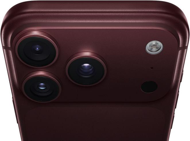 Un iPhone 18 Pro Max, couleur bourgogne (rouge foncé), face arrière, système caméra Pro Fusion dans la partie supérieure, 3 objectifs, lames d’ouverture variable partiellement fermées, flash, microphone et scanneur LiDAR, dessus, antenne cellulaire, côtés plats, bords arrondis