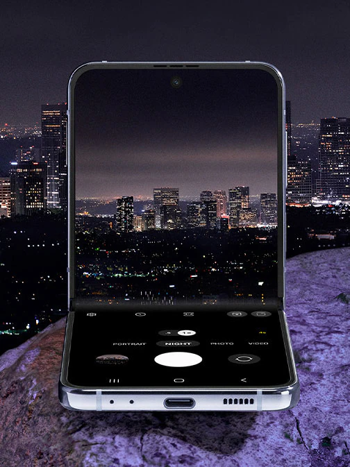 Galaxy Z Flip4 in Flex
						mode. The camera is seen on the Main Screen in Night mode. It is showing a preview of a city skyline at night.
						Night mode makes the colour and details of the city lights vivid and clear.
