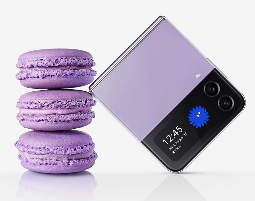A folded Galaxy Z
				Flip4 in Bora Purple seen from the Cover Screen. It leans against a stack of three macarons of the same colour. The
				folded device is similar in size to three stacked macarons.