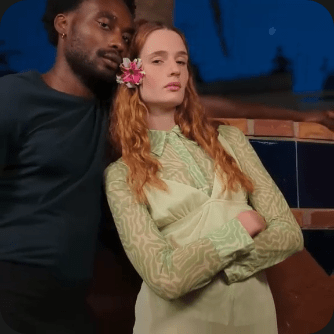 Close-up of a couple leaning against each other zooms out to include a blurred palm tree in the background