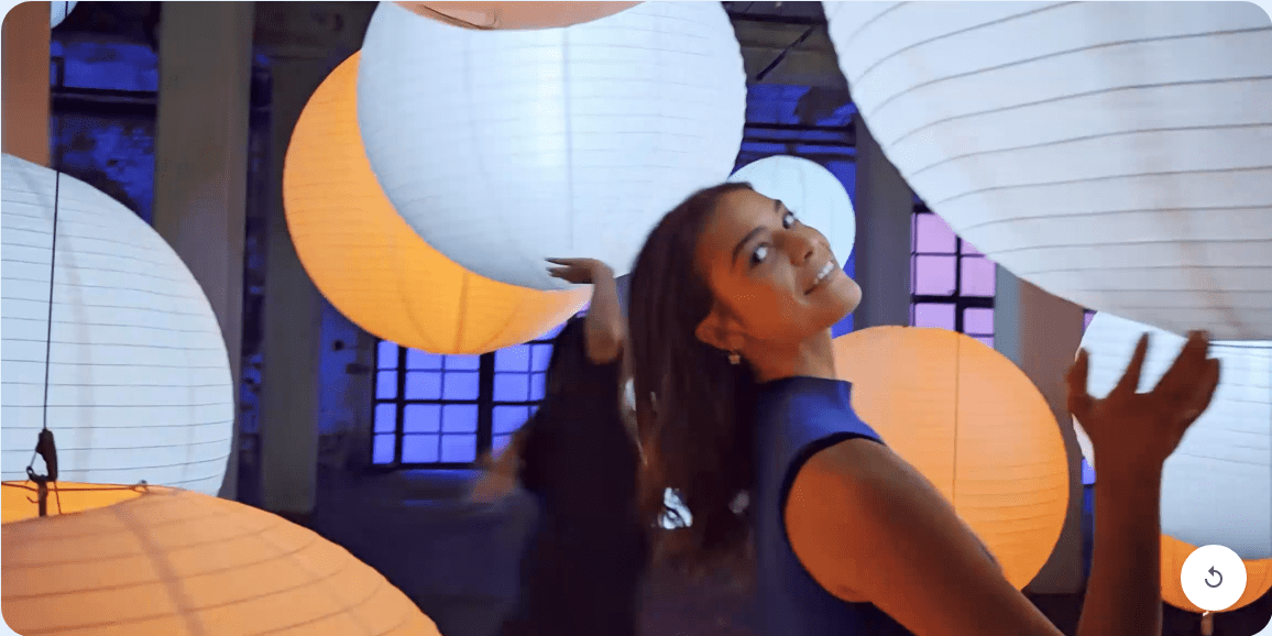 A crystal-clear video person standing in the middle of paper lanterns. The Pixel Camera makes the video quality extra sharp and velvety smooth.